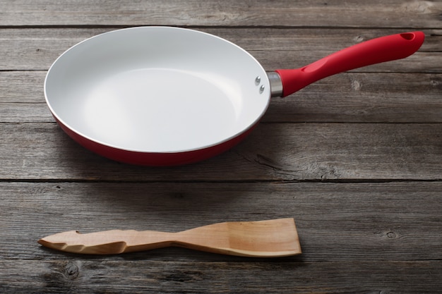 Frying pan on old wooden background