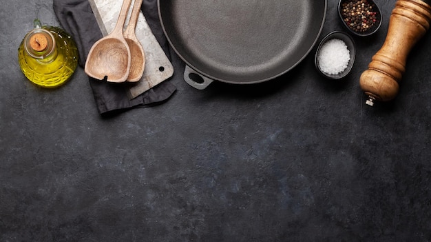 Frying pan utensils and ingredients on kitchen table