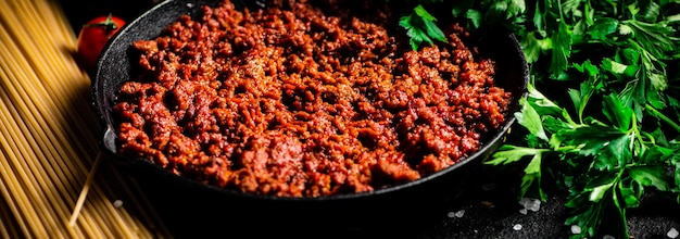 Frying pan with bolognese sauce on the table