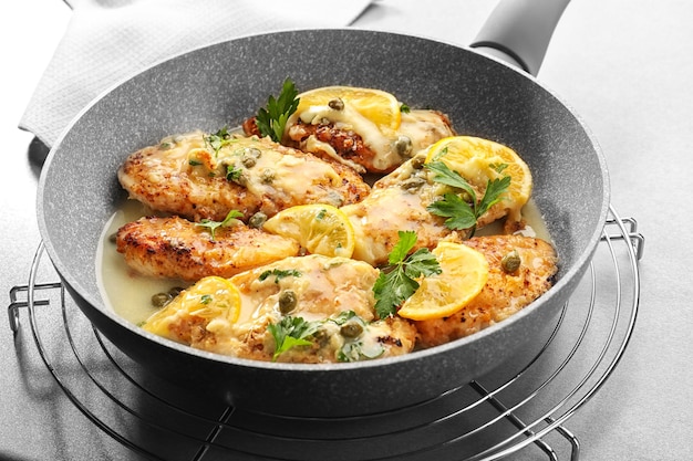 Frying pan with delicious chicken piccata closeup