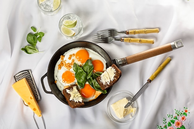 Frying pan with fried eggs on a light space. white tablecloth