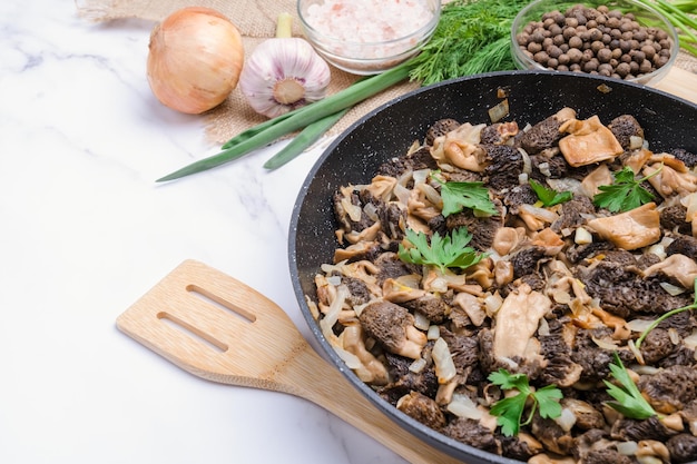 Frying pan with fried spring mushrooms morels