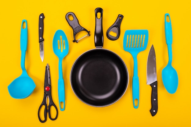 Frying pan with kitchen utensils isolated 