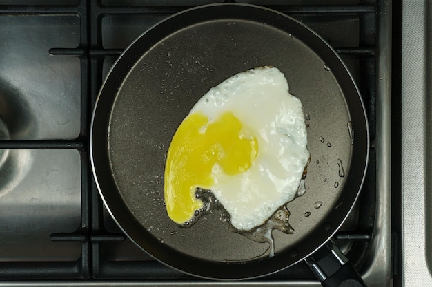 A frying pan with scrambled eggs is on the stove Closeup