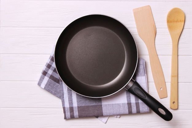 Frying pan and on the wooden table top view cooking