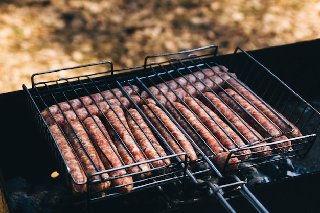 frying sausages on grates in nature