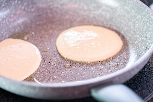 Frying small pancakes on a kefir base in a frying pan.