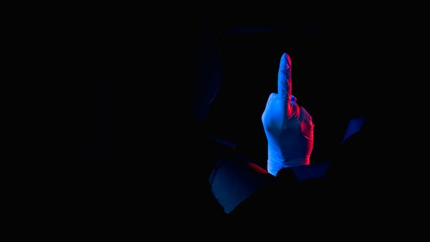 Fuck off obsceen gebaar rood blauw neon licht onbeleefd arts hand in handschoen met middelvinger binnen doorbraak gescheurde muur gat geïsoleerd op zwarte nacht lege ruimte banner