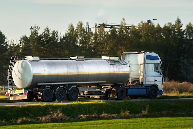 Fuel Delivery Liquid Fuel and Oil Cargo Semi Truck on the Highway Hauling Petroleum Products Compressed Gas Carrier Truck in the Evening Light