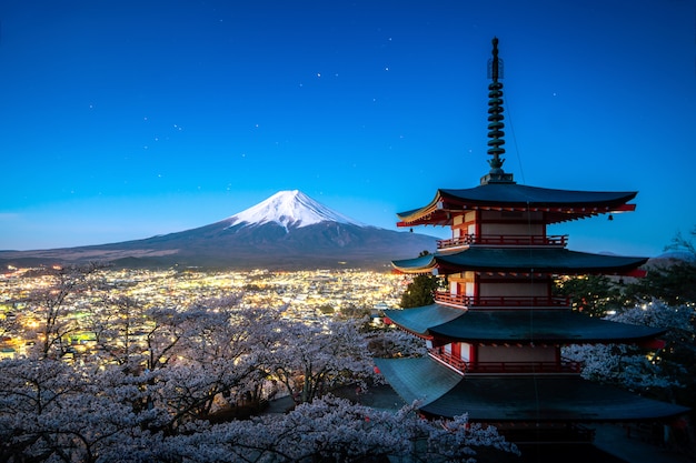 Fujiyoshida, Japan at Chureito Pagoda and Mt. Fuji in the spring with cherry blossoms full bloom during twilight. Japan