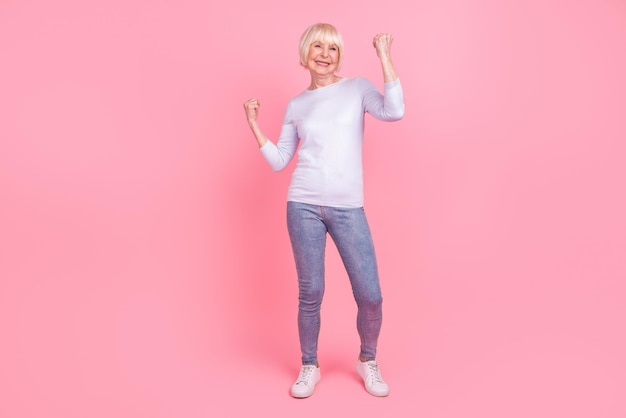 Full body foto van senior mooie vrouw verheugen overwinning succes doel hoera korting geïsoleerd over roze kleur achtergrond