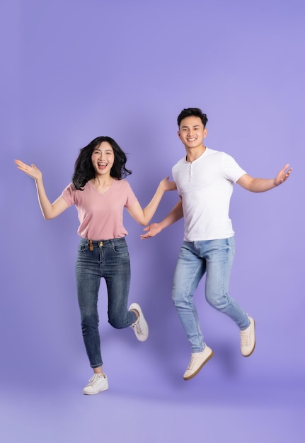 보라색 배경에 포즈 아시아 커플의 전신 이미지