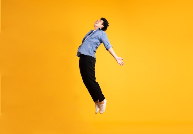 Full body image of asian man posing on yellow background