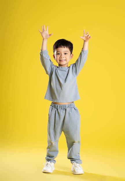 Full body image of boy posing on a yellow backgroundxA