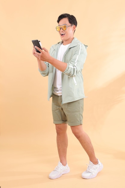 Full body length of a young handsome happy cheerful Asian male adult man