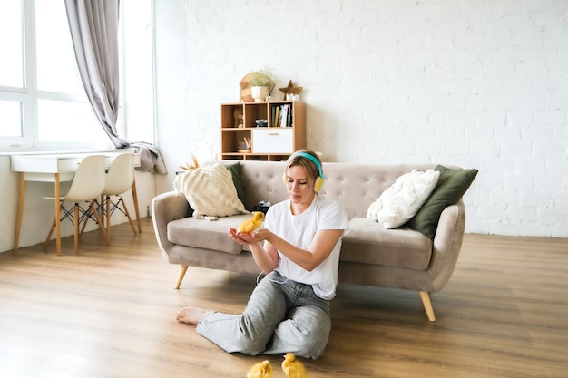 Full body photo of happy pretty girl sit floor inside home indoors with chicks