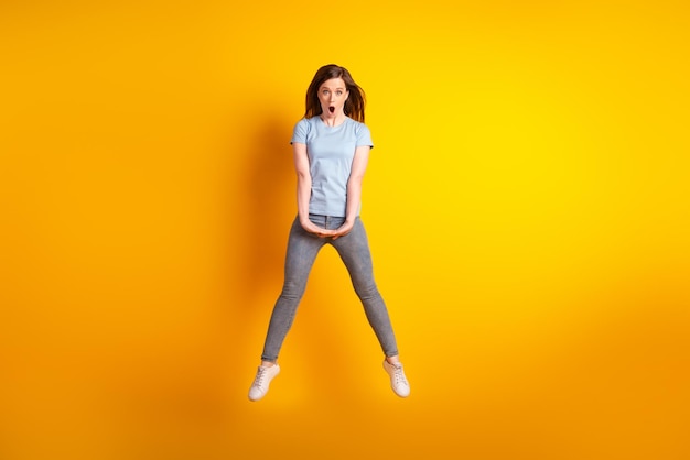 Full body photo of young astonished girl omg reaction fake information isolated over yellow color background