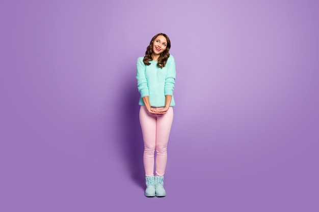 Full body portrait of beautiful pretty lady curly hairstyle good mood look up empty space dreamer wear fluffy pastel sweater pink pants shoes.