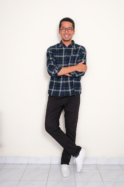 Full body portrait of a man standing confident with arms crossed showing happy expression