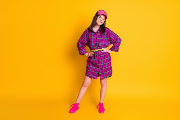 Photo full body portrait of satisfied young lady put hands on waist headwear isolated on bright yellow color background