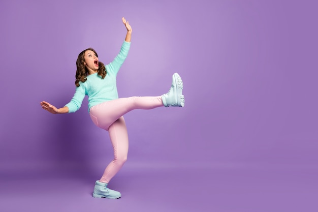 Full body profile portrait of frightened crazy lady raise leg high walk slippery road fall down wear casual fluffy jumper pink pastel pants shoes.