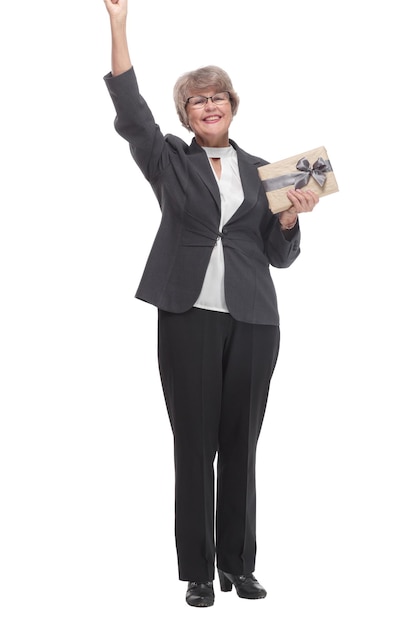 Full body senior woman happy and smiling holding a gift and pointed on it