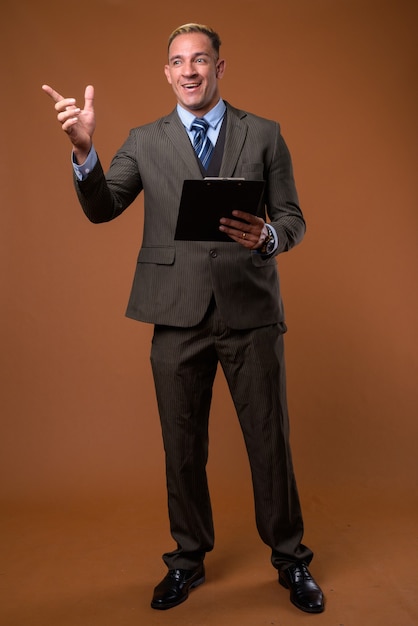 Full body shot of businessman holding clipboard