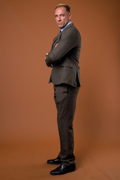 Full body shot of businessman standing on brown