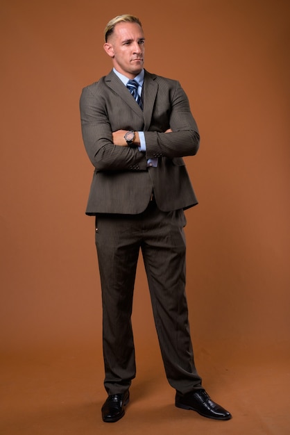 Full body shot of businessman standing on brown