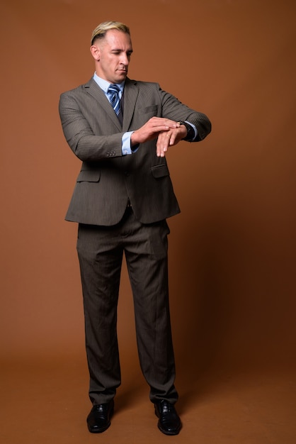 Full body shot of businessman standing on brown