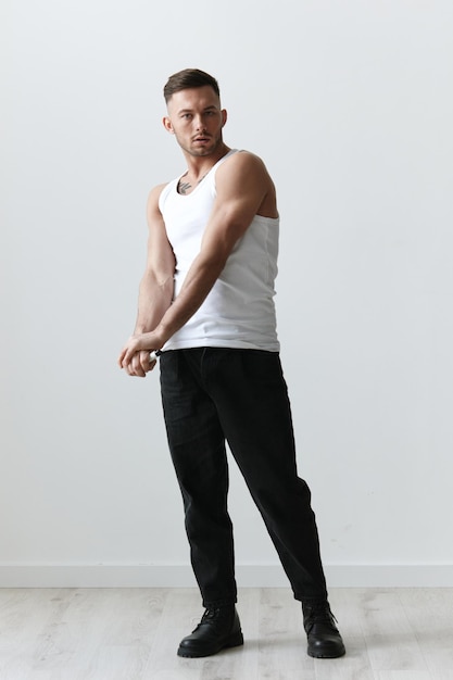 Full body shot of handsome tanned sporty attractive serious man\
guy posing on white studio background fashion style new collection\
offer copy space for ad modeling snapshots