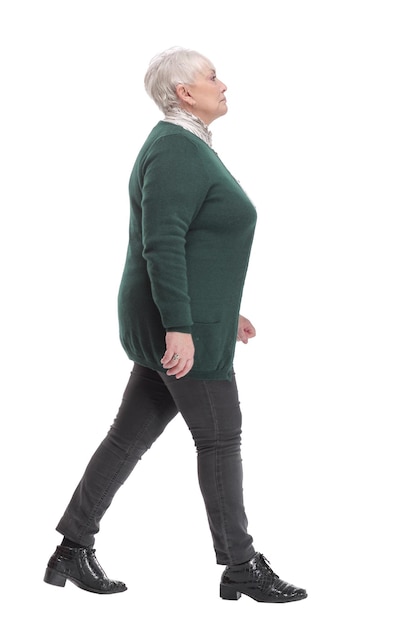 Full body shot profile view of senior businesswoman walking against white background