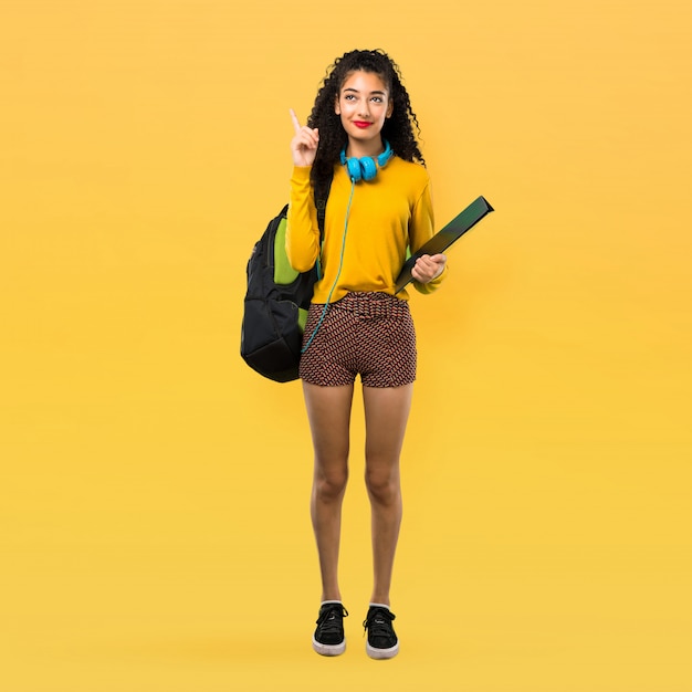 Full body of Teenager student girl with curly hair standing and thinking an idea pointing 