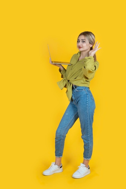 Full body young blonde caucasian girl carry open laptop hold hand near ear trying to hear