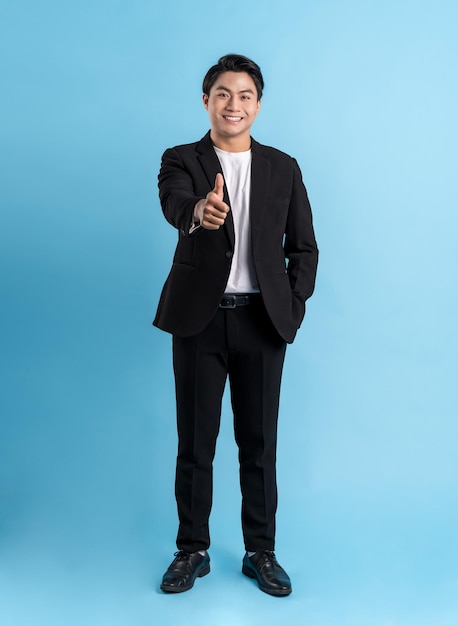 Full body Young business man wearing a vest posing on a blue background