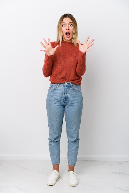 Full body young caucasian woman celebrating a victory or success, he is surprised and shocked.