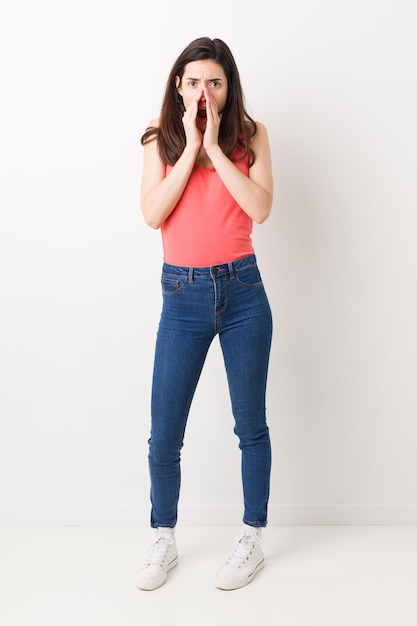 Full body young woman on white background shouting excited to front.