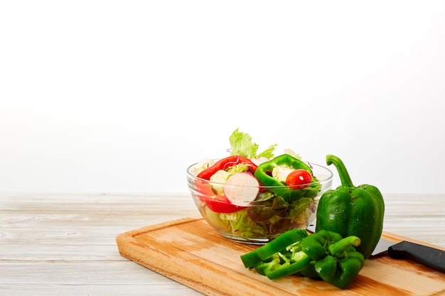 Full bowl of fresh salad on a white wooden