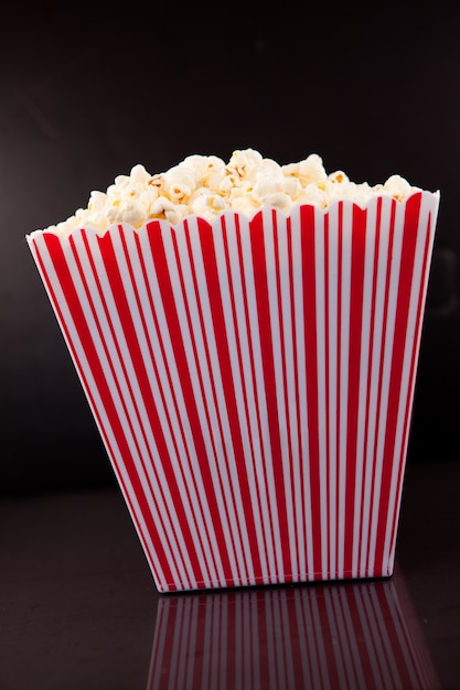 Full box of pop corn on a black table