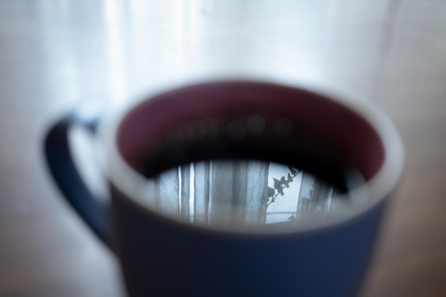 표면에 창 반사가 있는 커피 한 잔