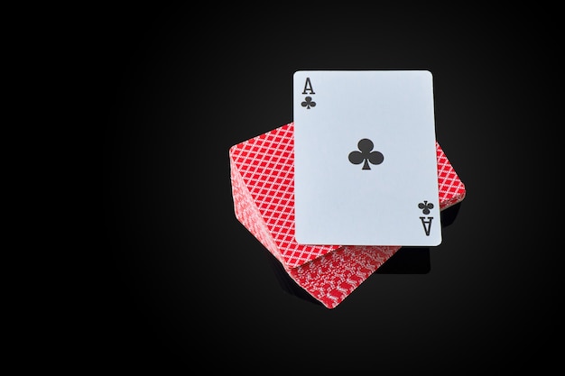 Full deck of playing cards with ace on top on dark reflective background