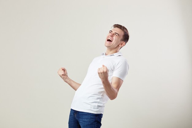 full of energy joyful guy happily shouts in the studio on a white background 