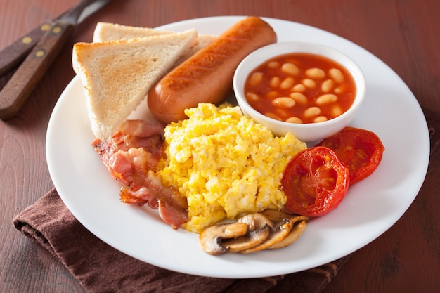 Full english breakfast with scrambled eggs, bacon, sausage, beans and tomato