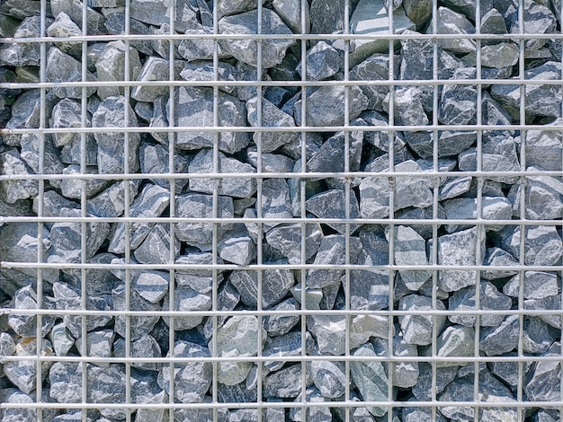 Full Frame Background of Gravel Stones Wall with Metal Wire Mesh