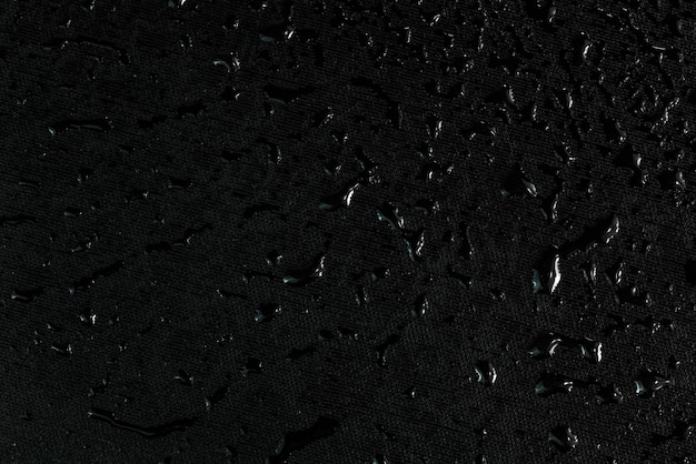 Photo full frame background of wet black surface with water drops