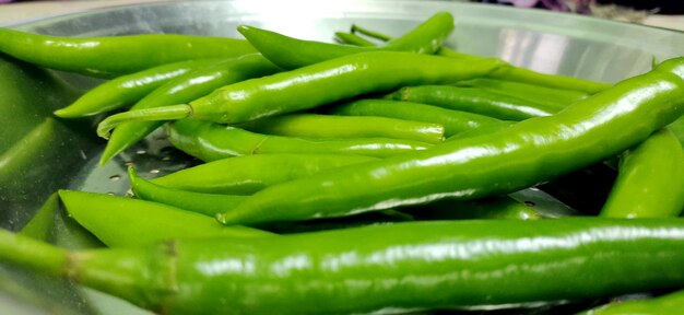 Full frame close up of a bunch of bright and shiny green chili p