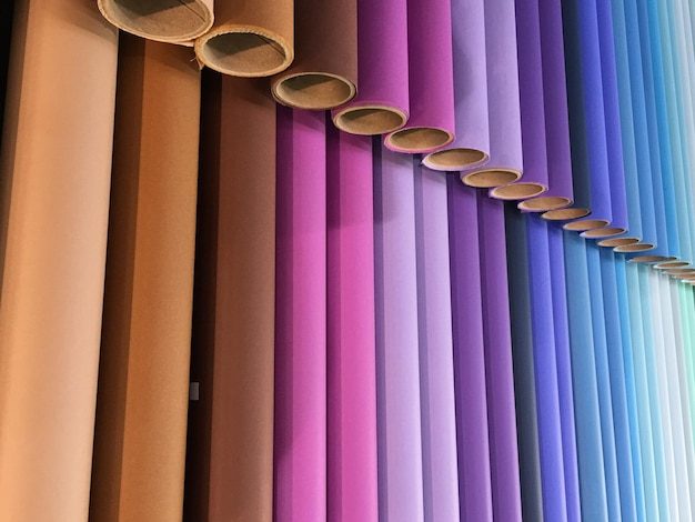 full frame shot of colorful fabrics rolled around cardboard at store
