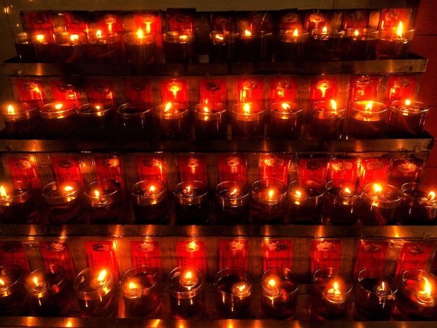 Photo full frame shot of illuminated candles on shelf