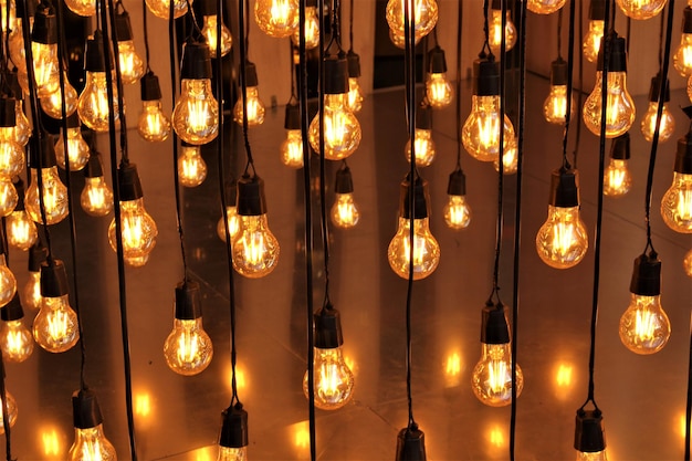 Photo full frame shot of illuminated light bulbs hanging at night