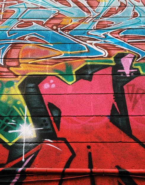 Photo full frame shot of multi colored graffiti on wall
